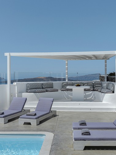 Shaded outdoor seating area by the pool and sunbeds