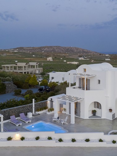 Evening aerial view of property and surrounding area