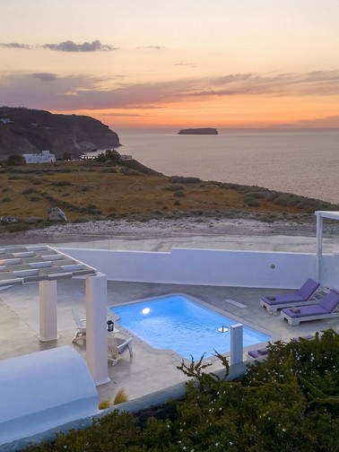 Villa in the foreground and orange sunset streak in background
