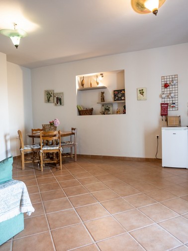 Small fridge, kitchen sink, and small dining table