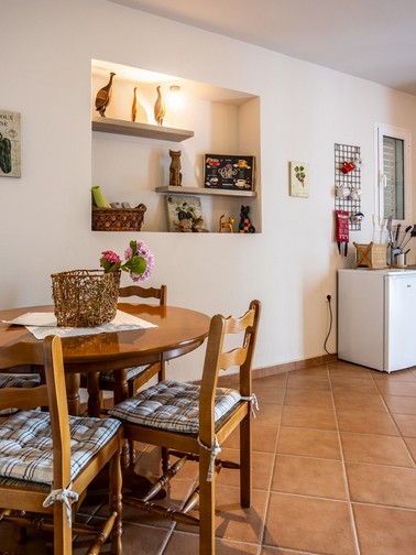 Small fridge, kitchen sink, and small dining table