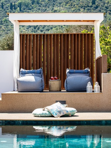 Pool and pouf sunbeds in shaded area