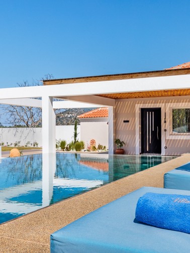 Pool, sunbeds, and villa entrance