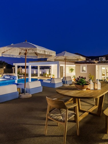 Outdoor dining area and pool by night