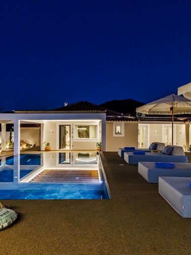 Pool and sunbeds by night